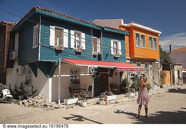 Frau fotografiert die traditionellen Holzhäuser im Stadtzentrum des antiken Tenedos  der heutigen Insel Bozcaada  Bozcaada  Canakkale  Ägäisregion  Türkei.