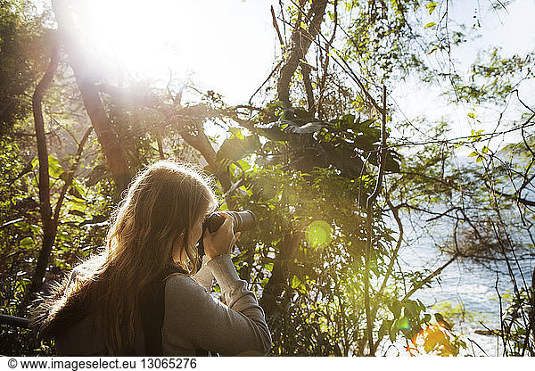 Frau fotografiert im Wald stehend