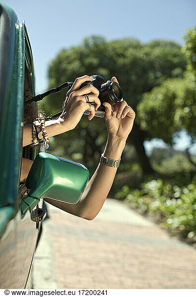 Frau fotografiert mit Kamera durch Autofenster