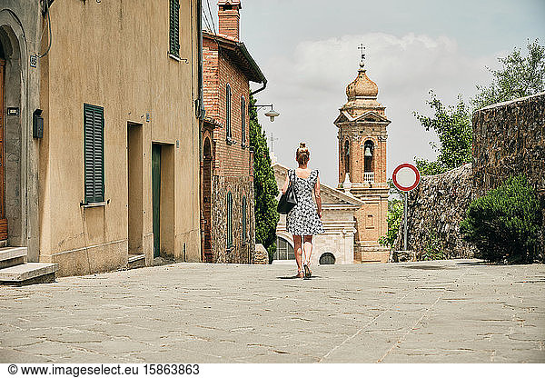 Frau geht alte Straße entlang mit Verbotsschild zur Kapelle