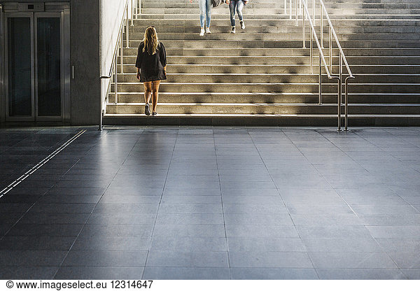 Frau geht eine Treppe hinauf