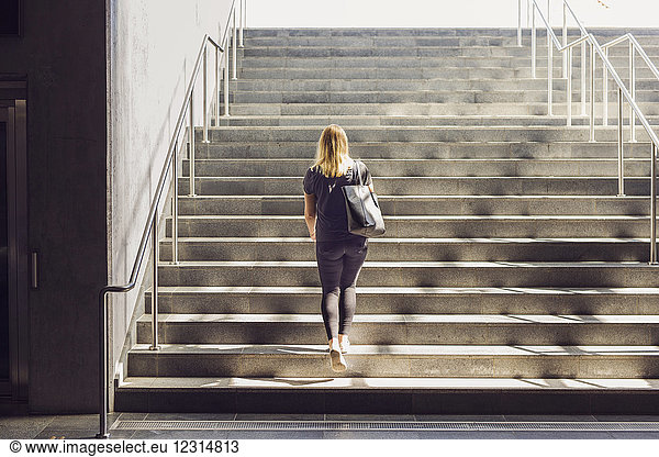 Frau geht eine Treppe hinauf