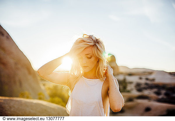 Frau genießt im Joshua-Tree-Nationalpark bei Sonnenschein gegen den Himmel