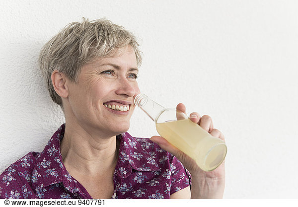 Frau Getränk lächeln halten reifer Erwachsene reife Erwachsene Flasche