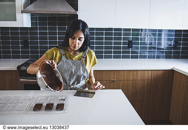 Frau gießt Schokoladensauce in Form