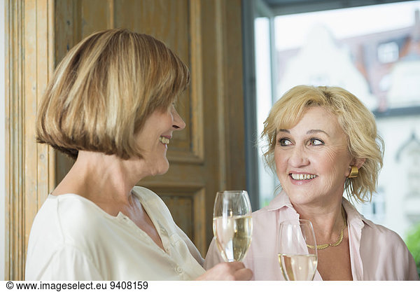 Frau Glas lächeln Wein halten glitzern Gespräch Gespräche Unterhaltung Unterhaltungen