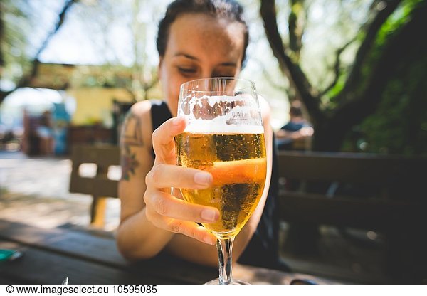 Frau hält ein Glas Bier hoch  Garda  Italien