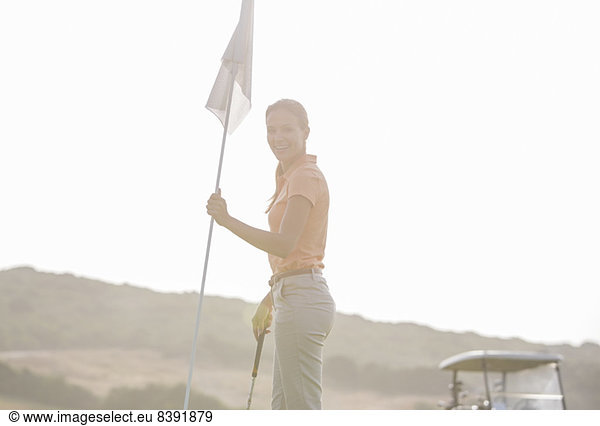 Frau hält Golfflagge