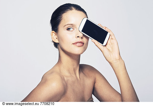 Frau hält Handy von Angesicht zu Angesicht