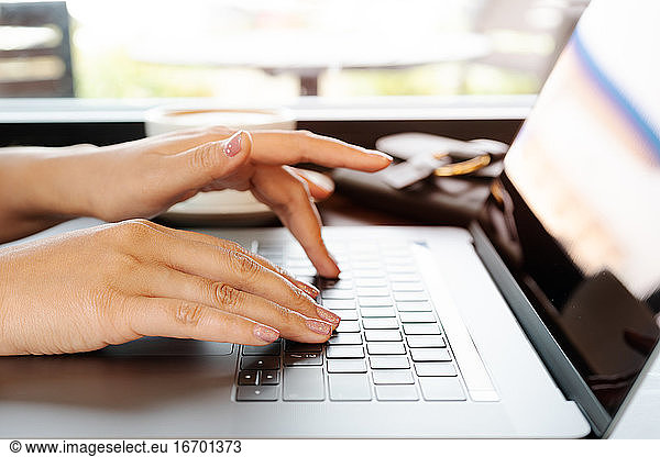 Frau Hände tippen auf Laptop-Tastatur. Frau arbeitet im Büro w