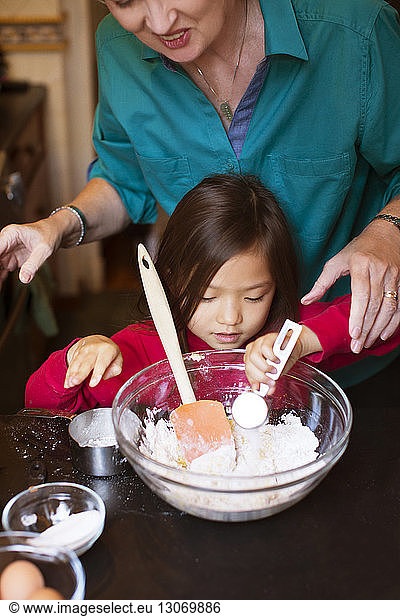 Frau hilft Enkelin bei der Zubereitung von Essen zu Hause