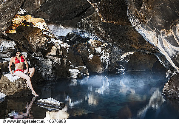 Frau in der Grjotgja-Höhle im Norden von Island