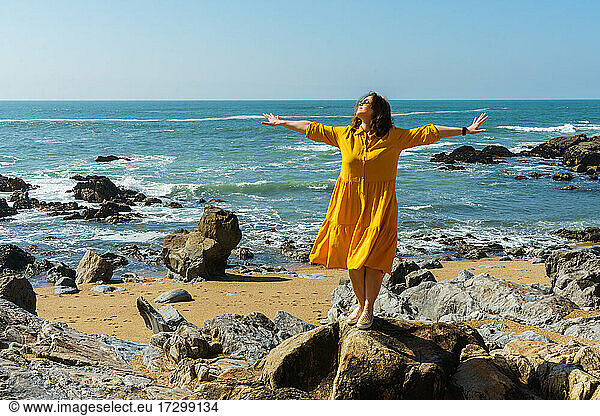 Frau in einem gelben Kleid glücklich mit Meer Hintergrund im Urlaub am Meer.