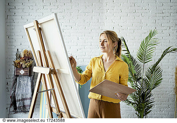 Frau in Freizeitkleidung malt zu Hause