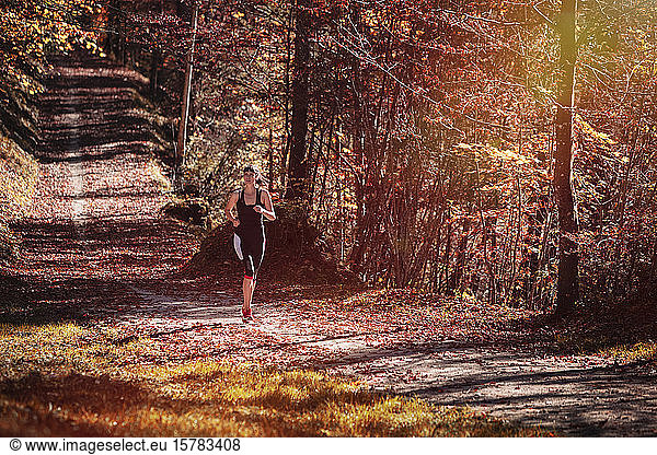 Frau joggt im Herbstwald