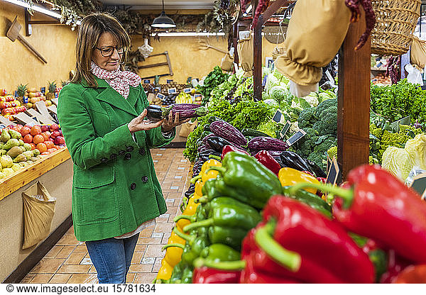 Frau kauft Obst und Gemüse im Bioladen