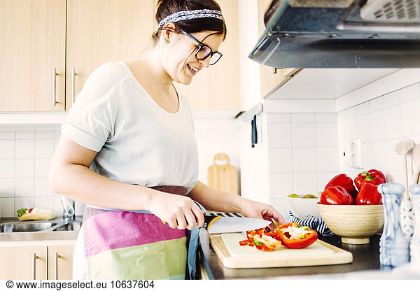 Frau lächeln schneiden Küche rot Peperoni Glocke Tresen