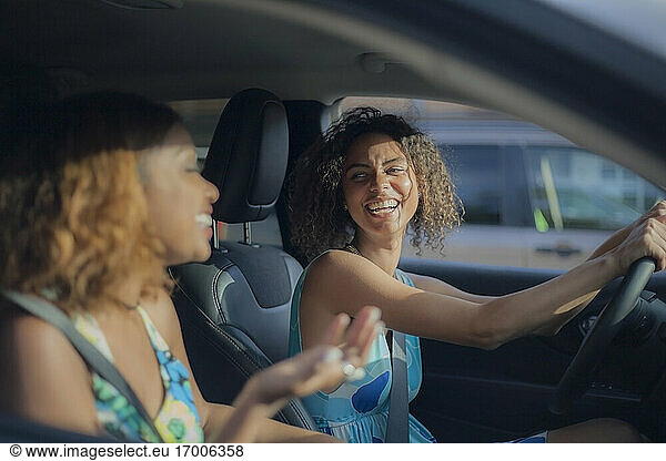 Frau lacht beim Anblick einer Freundin im Auto