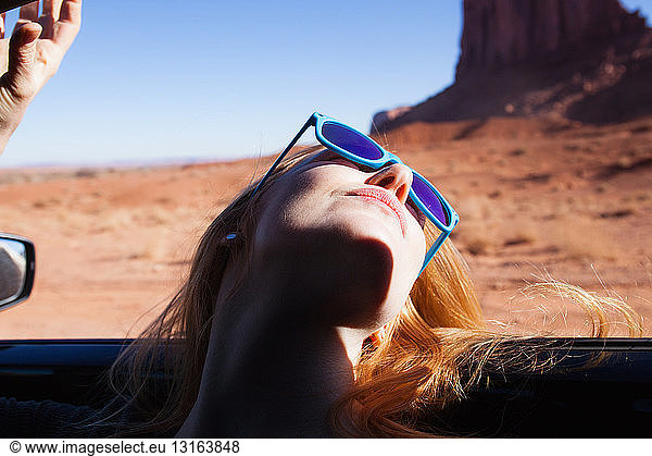 Frau lehnt sich aus dem Autofenster zurück  Monument Valley  Utah  USA