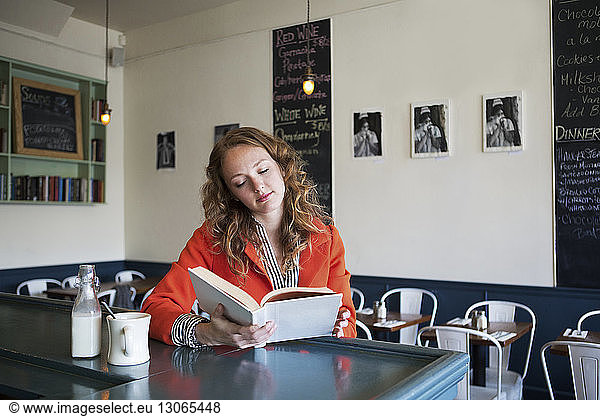 Frau liest Buch im Cafe