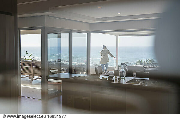 Frau mit Blick auf sonnigen Blick auf das Meer auf Luxus nach Hause Schaufenster Balkon