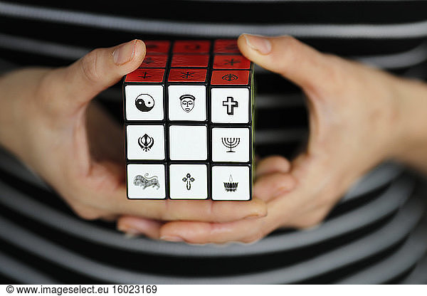 Frau mit einem Rubik-Würfel mit religiösen Symbolen