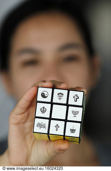 Frau mit einem Rubik-Würfel mit religiösen Symbolen