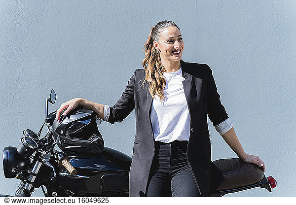 Frau mit Helm auf Motorrad sitzend