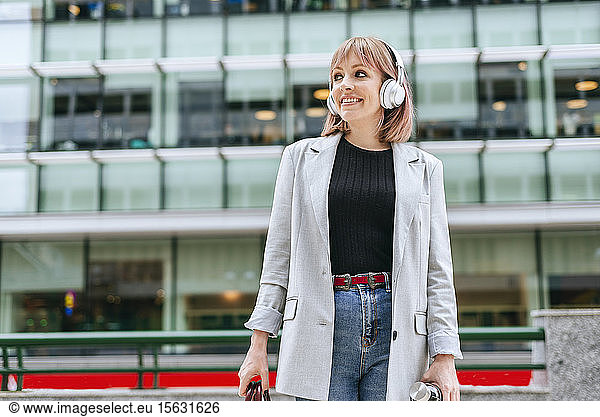 Frau mit Kopfhörern in der Stadt unterwegs