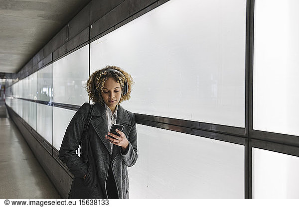 Frau mit Kopfhörern und Smartphone