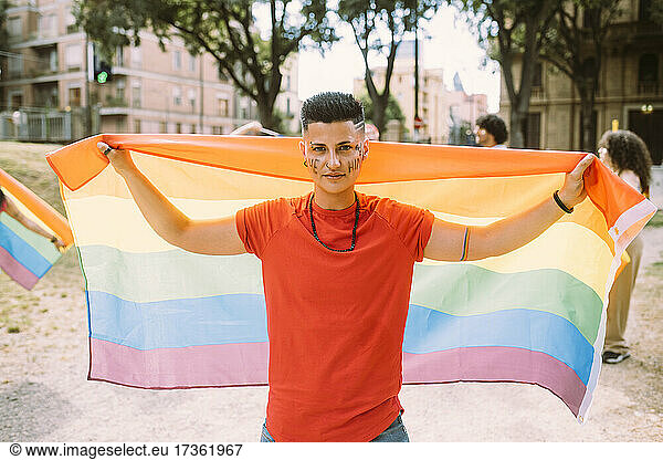 Frau mit Regenbogenfahne bei Pride-Event im Park