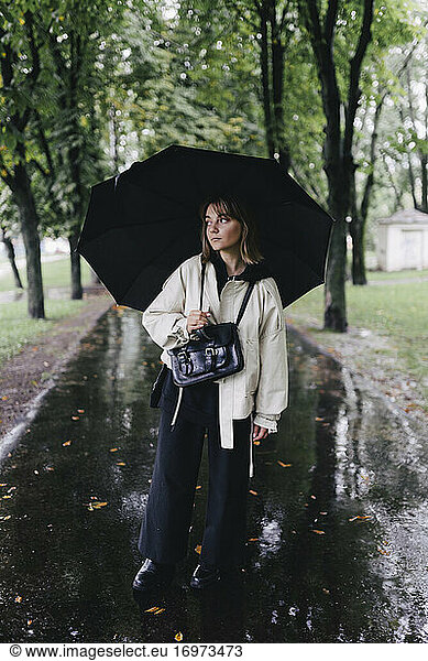 Frau mit Regenschirm bei regnerischem Wetter