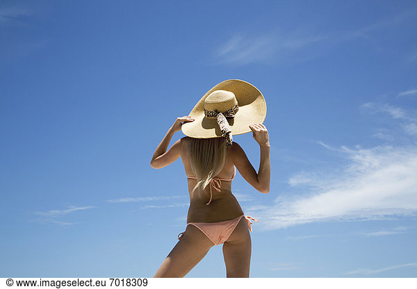 Frau mit Sonnenhut und Bikini