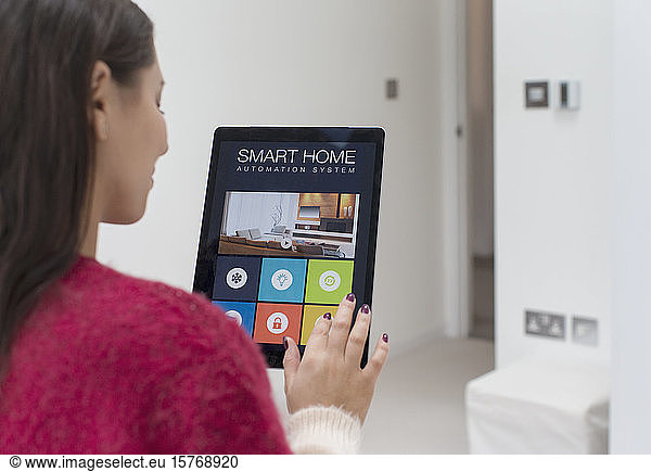 Frau nutzt intelligentes Hausautomatisierungssystem mit digitalem Tablet