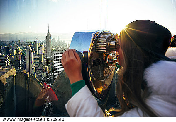 Frau oben auf dem Felsen (Woman on Top on the Rock) schaut durch ein Fernglas  New York City  Vereinigte Staaten