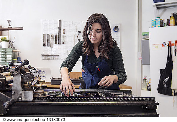 Frau ordnet Alphabete auf Maschinen in der Werkstatt