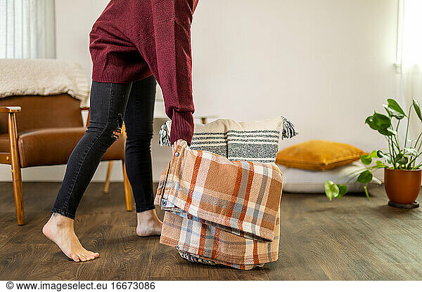 Frau packt Korb mit Decke und Kissen