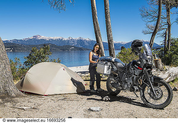 Frau packt Motorrad im Camp am Nahuel Huapi See in Patagonien