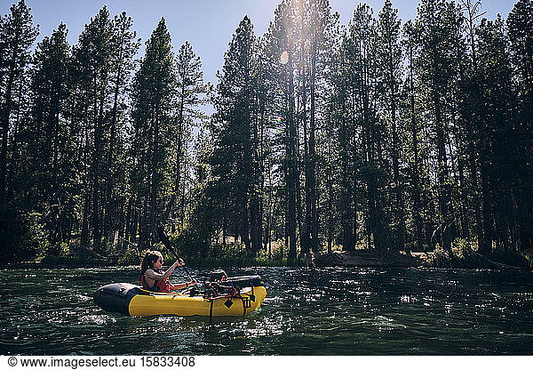 Frau paddelt mit ihrem Ruderfloß den Deschutes River in Zentral-Oregon hinunter