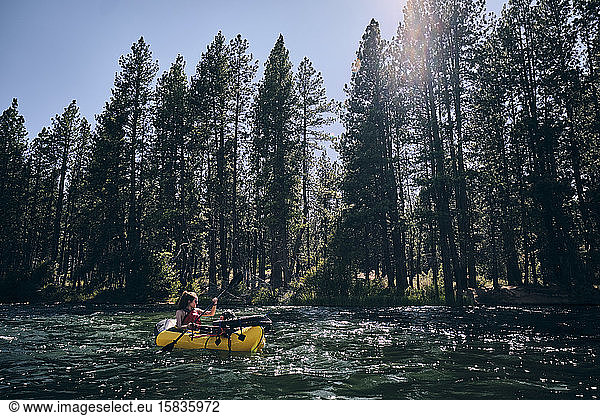 Frau paddelt mit ihrem Ruderfloß den Deschutes River in Zentral-Oregon hinunter