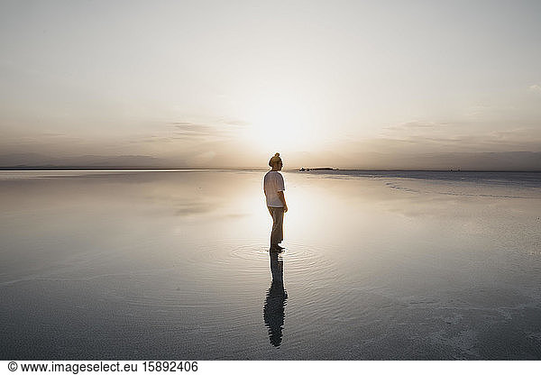 Frau reflektiert über Wasser am Karum-See bei Sonnenuntergang  Danakil-Depression  Äthiopien  Afar