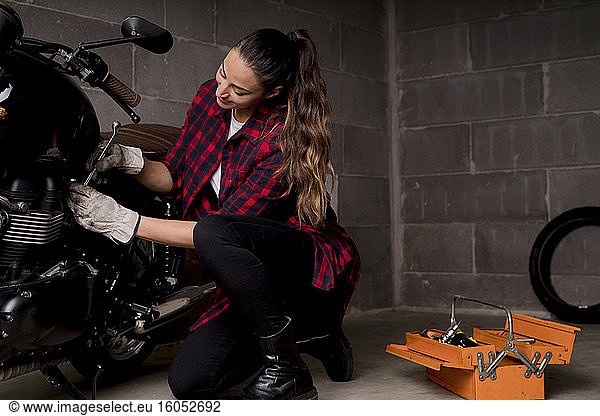 Frau repariert Motorrad