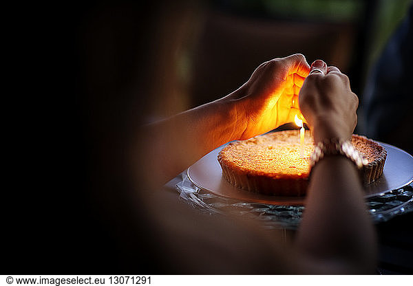 Frau schützt brennende Kerze