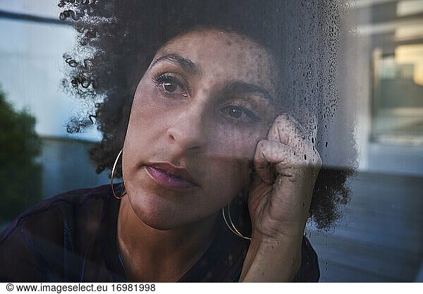 Frau schaut durch nasses Glas