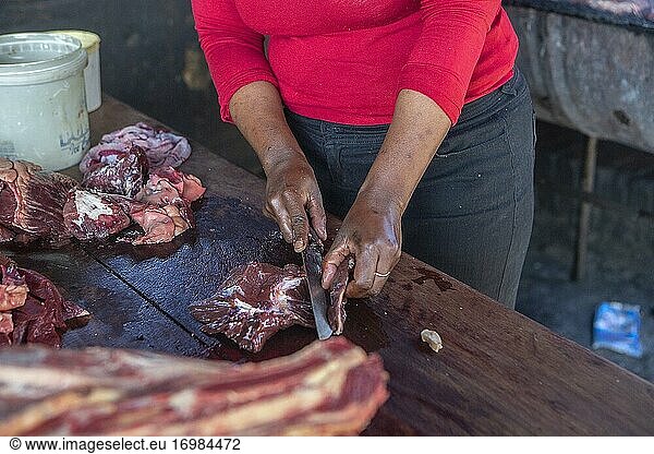 Frau schneidet Fleisch für Shisenyama (Grill)  Johannesburg  Südafrika
