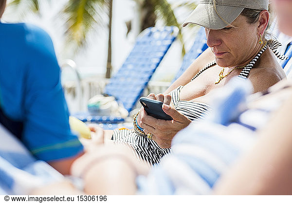 Frau schreibt im Urlaub per Smartphone SMS