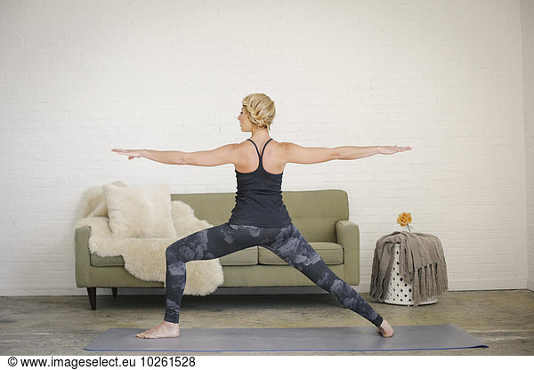 Frau schwarz Arme ausbreiten Arme ausstrecken Trennung Yoga strecken Turnanzug blond Leggins Matte