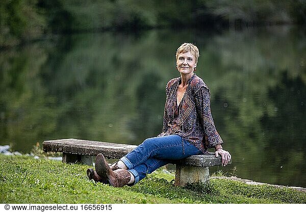 Frau sitzt am See und schaut in die Kamera - Brevard  North Carolina  USA.