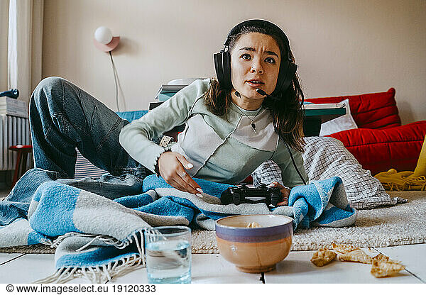 Frau spielt Videospiel im Wohnzimmer zu Hause