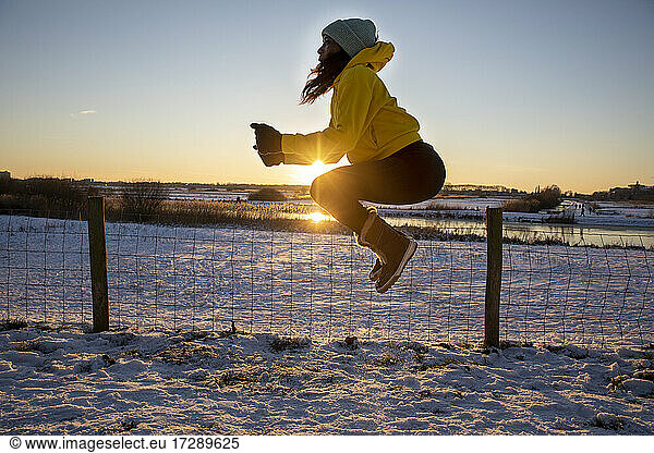 Frau springt beim Sport im Winter